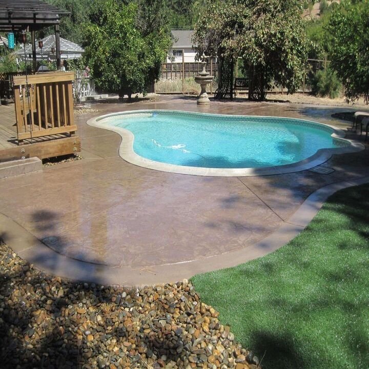 Warm brown stained concrete pool deck beside a swimming pool