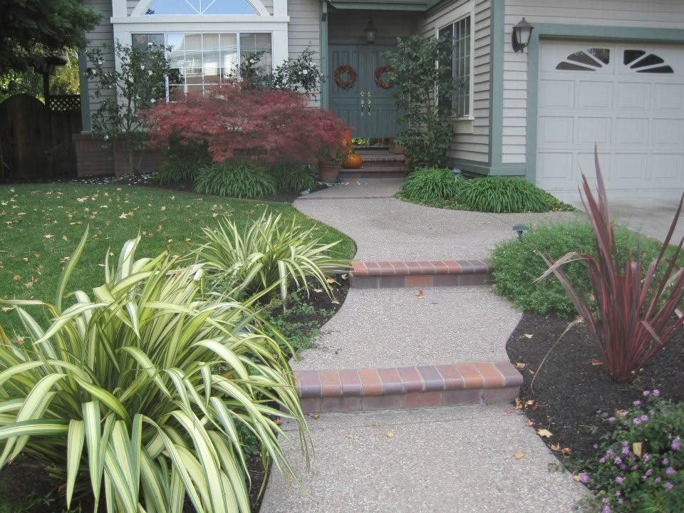 Exposed aggregate walkway with brick-edged steps leading to a front door